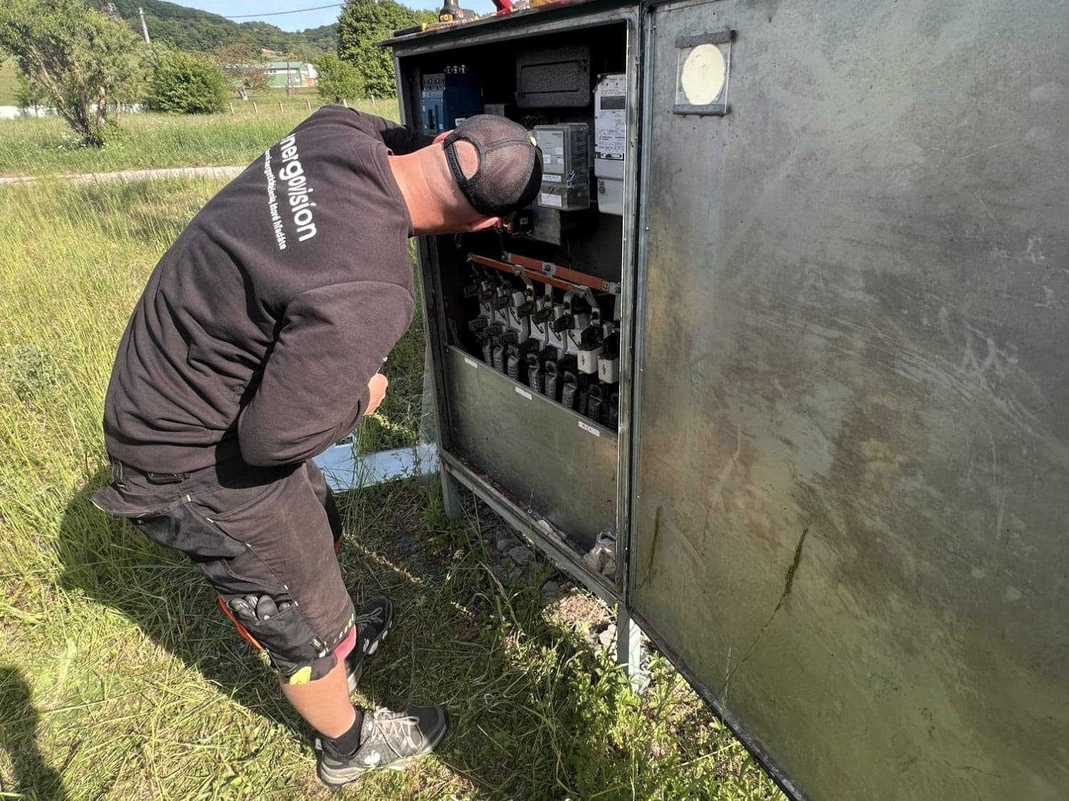 Elektrikár Energovision pracuje na NN rozvádzači pri stožiarovej trafostanici
