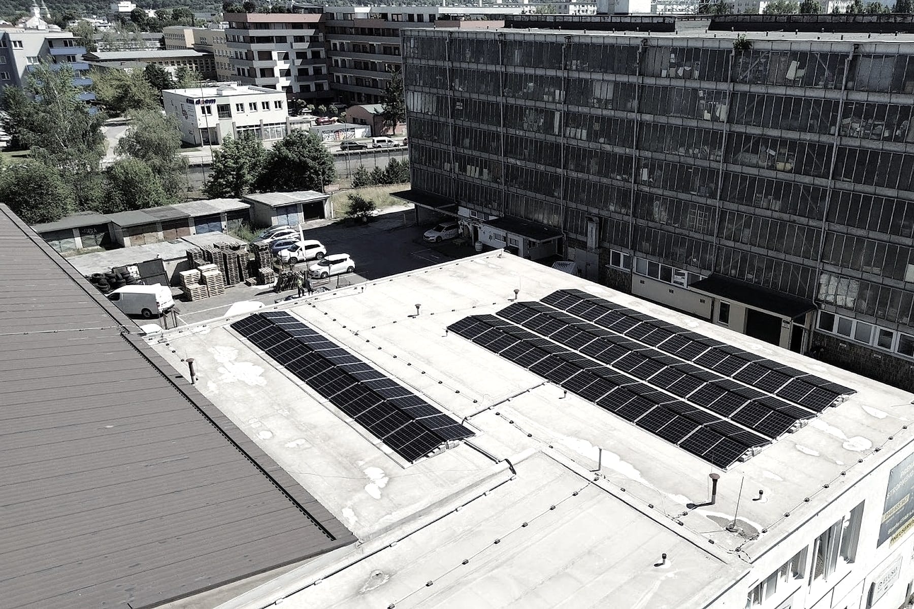 Ortofoto plochej strechy s fotovoltickou elektrárňou v Žiline, parkovisko a susedné budovy